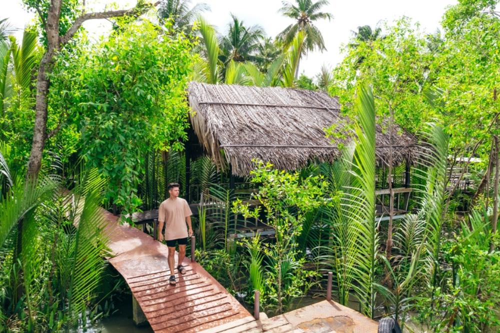 a man stays in Ben Tre homestay Vietnam surrounded by green jungle