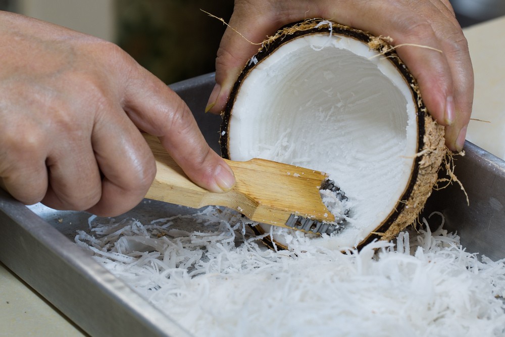 a person is using a coconut grater